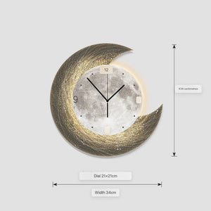 The Concentric Orbit Minimalist Wall Clock features a moon-inspired backlit design with a gold crescent, black hands, visible 9 and 12, sized at 34 cm wide with a 21x21 cm dial—ideal as statement lighting and for ambient mood light anywhere.