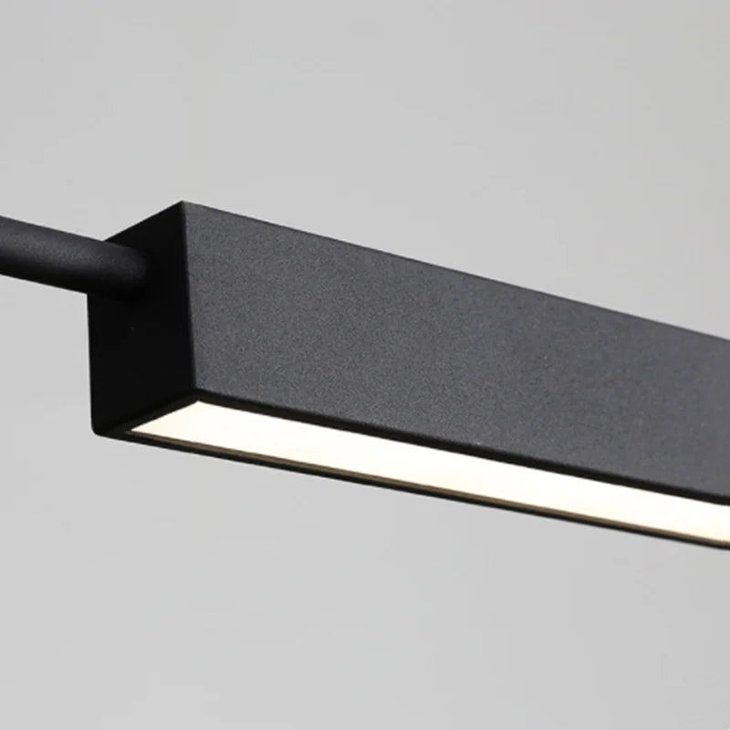 A minimalist black rectangular LED ceiling light is mounted horizontally, emitting a soft white glow. It's complemented by the Modern Track Lighting for an added touch of industrial-inspired elegance.