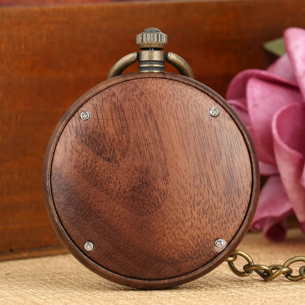 The Wooden Pocket Watch features a round wooden case, metal crown and chain, displayed on a textured surface with a pink rose—ideal for vintage watch enthusiasts.