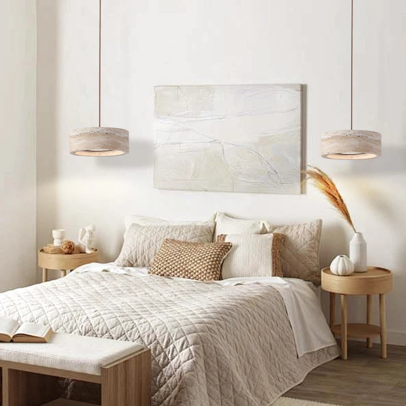 A neatly made bed with beige bedding, two round wooden nightstands, a Natural Stone Pendant Light, and a neutral abstract painting on the wall create a warm, modern bedroom ambiance.