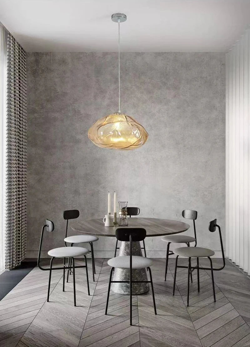 A modern dining area with a round table, four chairs, neutral gray tones, and the Luxe Cloud Glass Pendant Light hanging overhead.