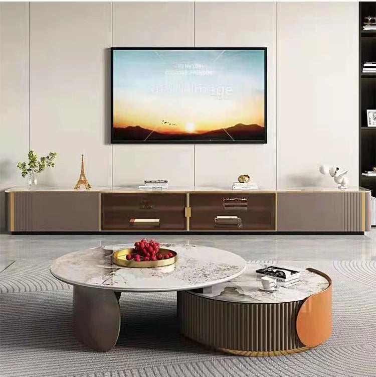 Modern living room featuring a wall-mounted TV, long console, decorative accents, and the Luxe Round Coffee Table—styled with a fruit tray—for an elegant yet functional centerpiece.