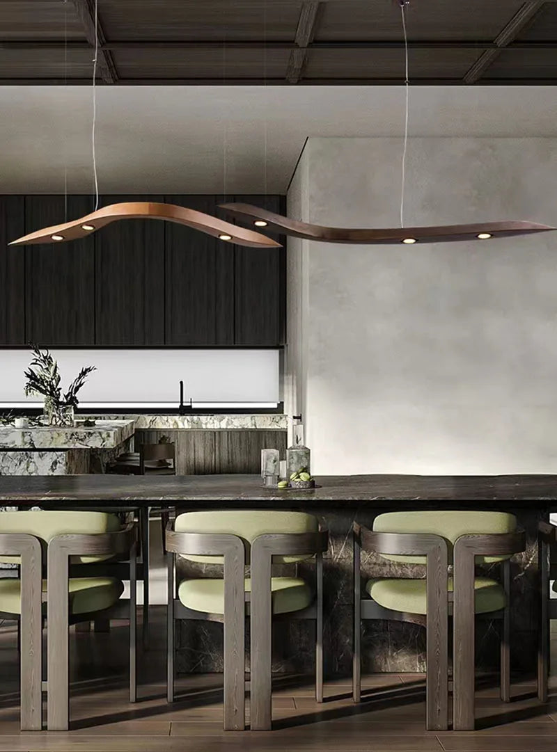 Modern kitchen with a marble island, four green cushioned chairs, and the Spiral Wood Pendant Light hanging elegantly above the counter for stylish modern home lighting.