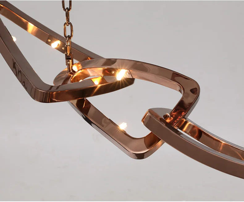 The Elegant Industrial Gallery Pendant features an abstract rose gold design with integrated LED lights, suspended by a chain against a plain light background.