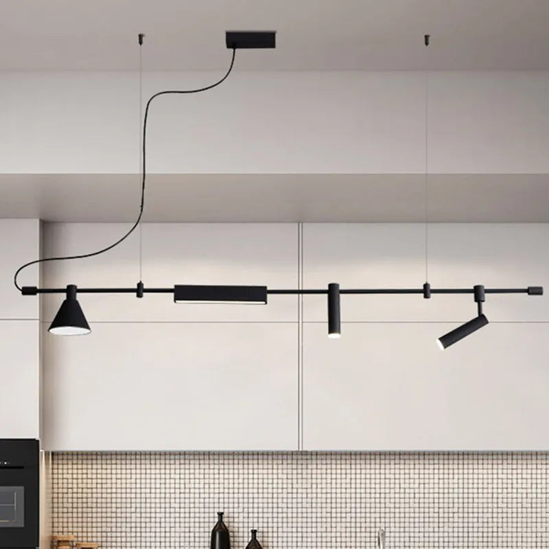 The Modern Track Lighting, a sleek black linear ceiling fixture with adjustable heads and cylindrical lights, enhances the minimalist kitchen's white cabinets and tiled backsplash, providing an industrial-inspired elegance.