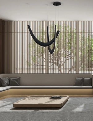 Modern minimalist living room with built-in gray seating, a low rectangular table, large windows, vertical wooden slats, and a striking Double Curve Wood Pendant Light.