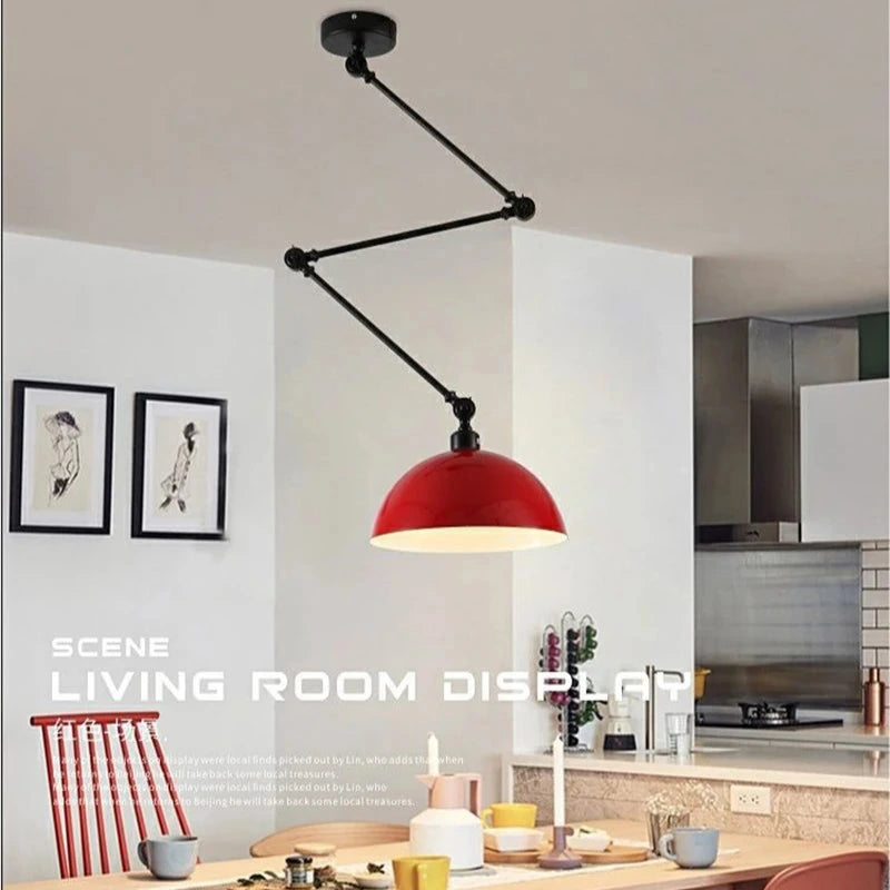 A modern kitchen features a Zig Zag Pendant Light with a red dome hanging over a wooden table set with cups and plates. Abstract art on the wall adds an industrial design charm, while a small stack of books rests on the counter.