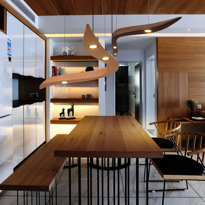 Modern dining area with a wooden table, black metal chairs, wood panel accents, built-in shelves, and the Spiral Wood Pendant Light for an organic modern lighting touch.