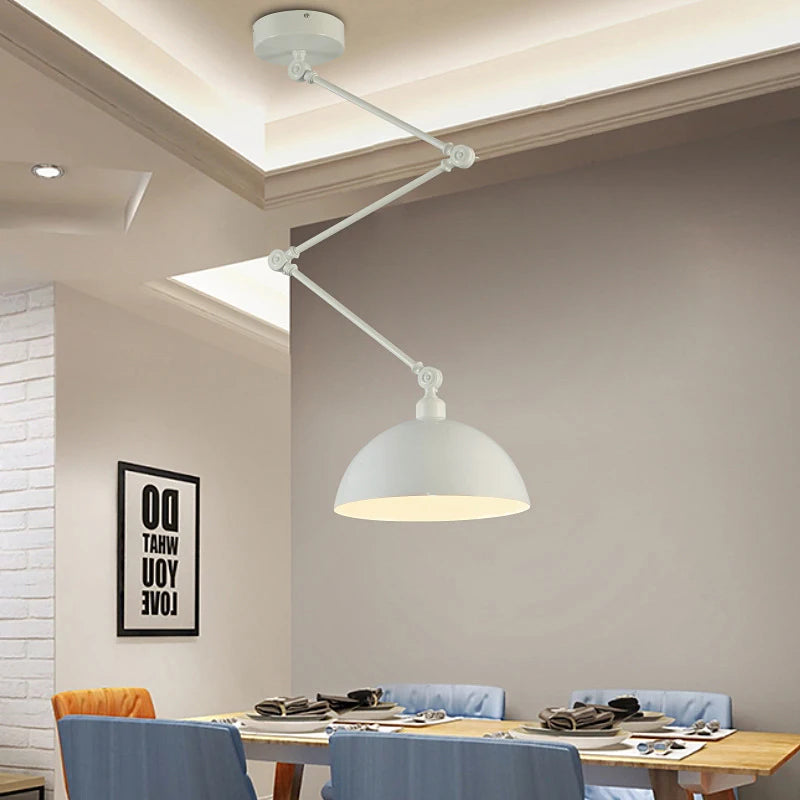 A modern dining room showcases the Zig Zag Pendant Light, an adjustable white ceiling lamp with an industrial design, hanging over a table set for four. Blue chairs surround the table, complemented by a charming text wall art piece.