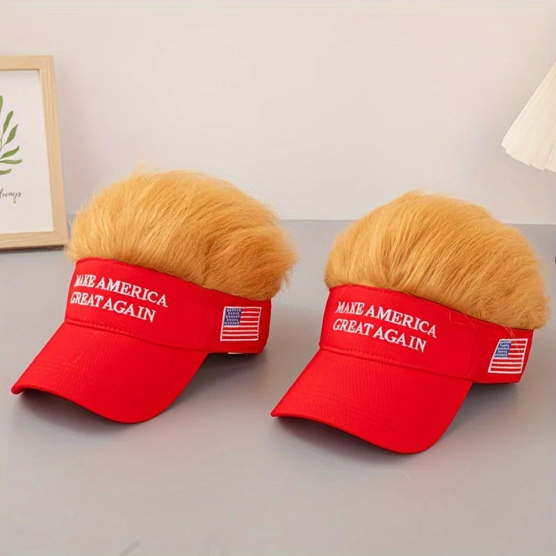 Two red Visor Cap - Make America Great Again visors with attached fake blond hair and small American flag patches rest on a gray surface—a playful, patriotic conversation starter.