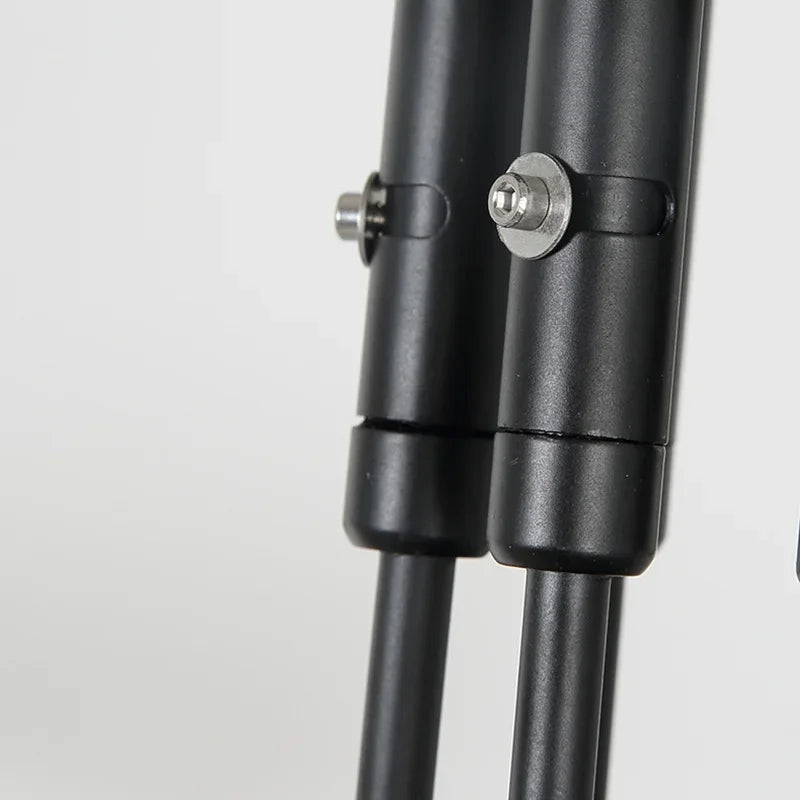 Close-up of the Sleek Industrial Pendant Light showcasing two black metal poles with adjustable bolts and brass connection points against a plain background.