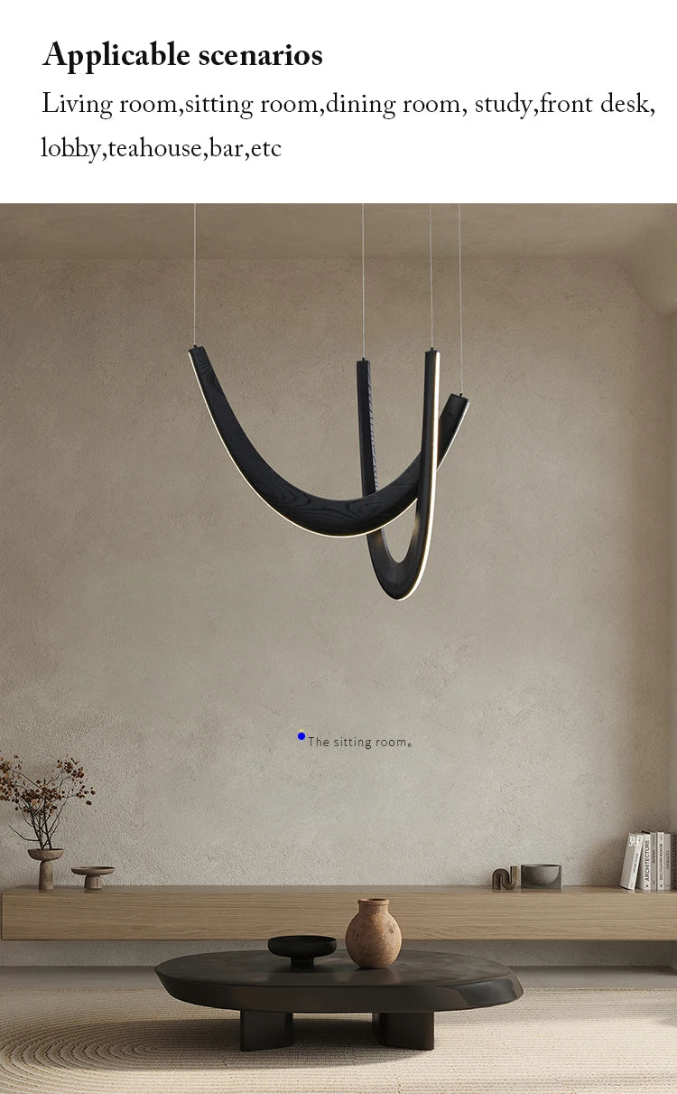 Minimalist living room featuring the Double Curve Wood Pendant Light, a low wooden bench, round black coffee table, and simple ceramic decor set against a neutral wall.