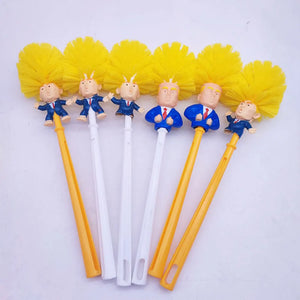 The Trump Tidy Toilet Brush set includes six novelty brushes, each featuring yellow bristles and a handle shaped with a caricature of a man in a suit with yellow hair at the base for humorous bathroom cleaning.