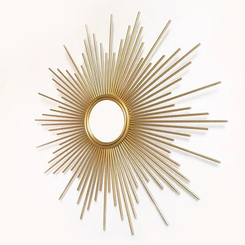 The Luxe Sunray Wall Mirror features a round gold sunburst frame with radiating metal rods, creating a stunning statement piece for any interior against a white background.