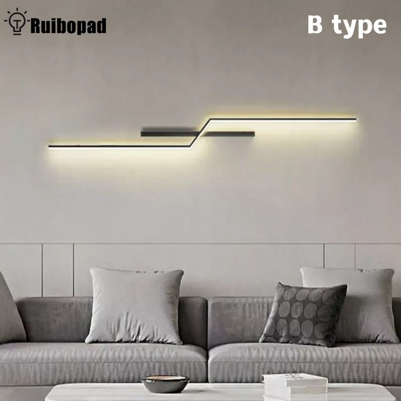 Minimalist Wall Sconce with geometric design is mounted above a grey sofa with three cushions in a neutral-toned living room. "Ruibopad" and "B type" text on the wall accentuate this decorative lighting piece.