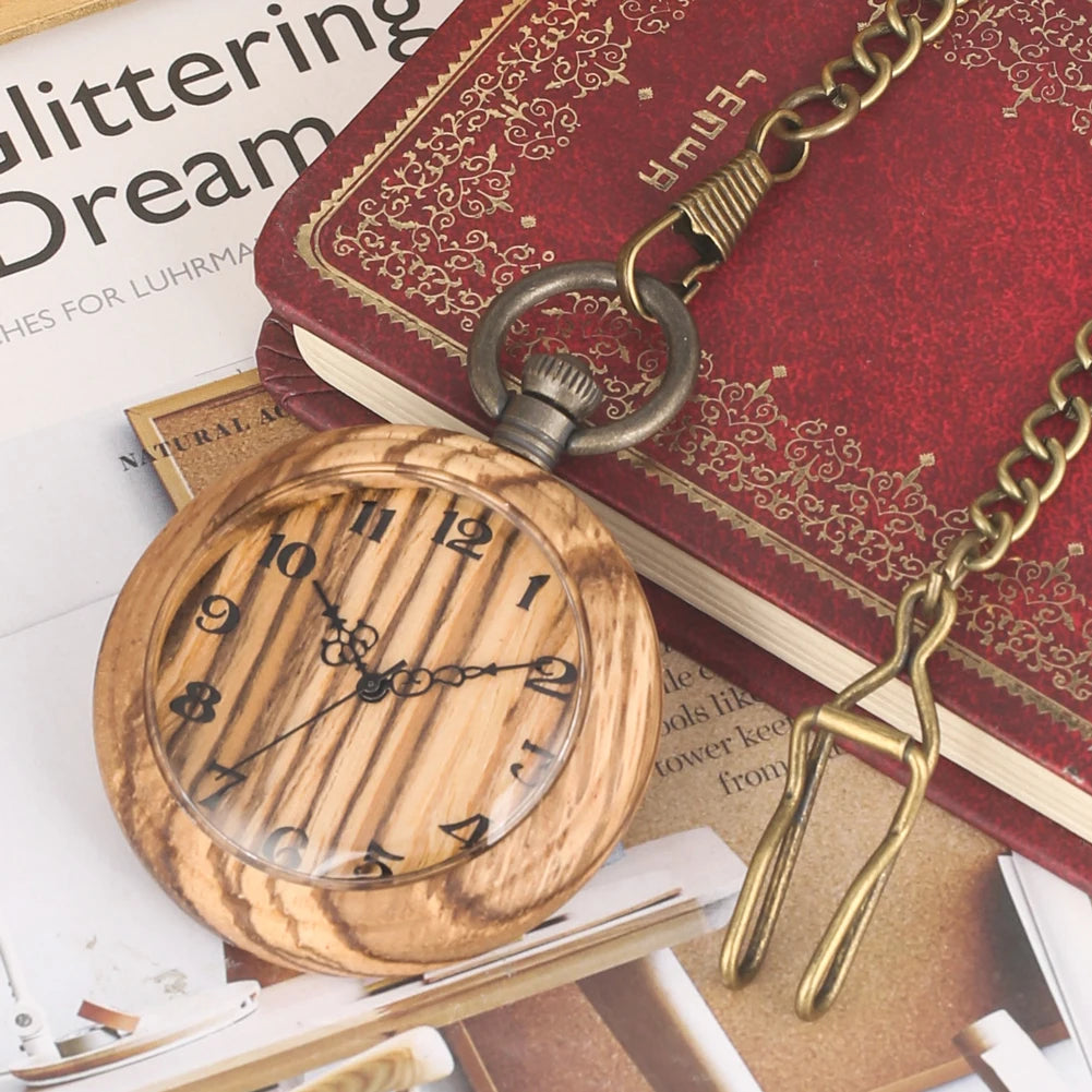 A Wooden Pocket Watch from the collection is displayed on an open magazine and a red embossed journal.