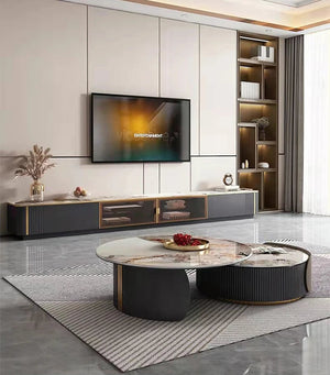 Modern living room with a wall-mounted TV, low black TV console, Luxe Round Coffee Table, built-in shelves, large rug, and floor-to-ceiling curtains.