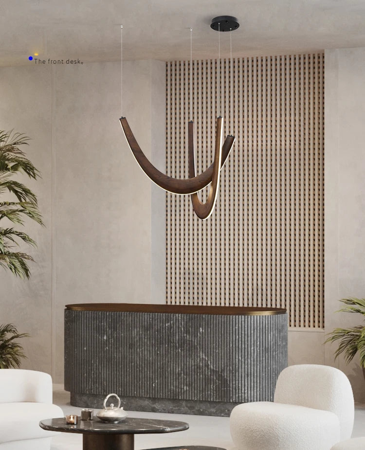 A modern reception area featuring a dark curved front desk, Double Curve Wood Pendant Light, vertical slat wall feature, and white contemporary chairs.