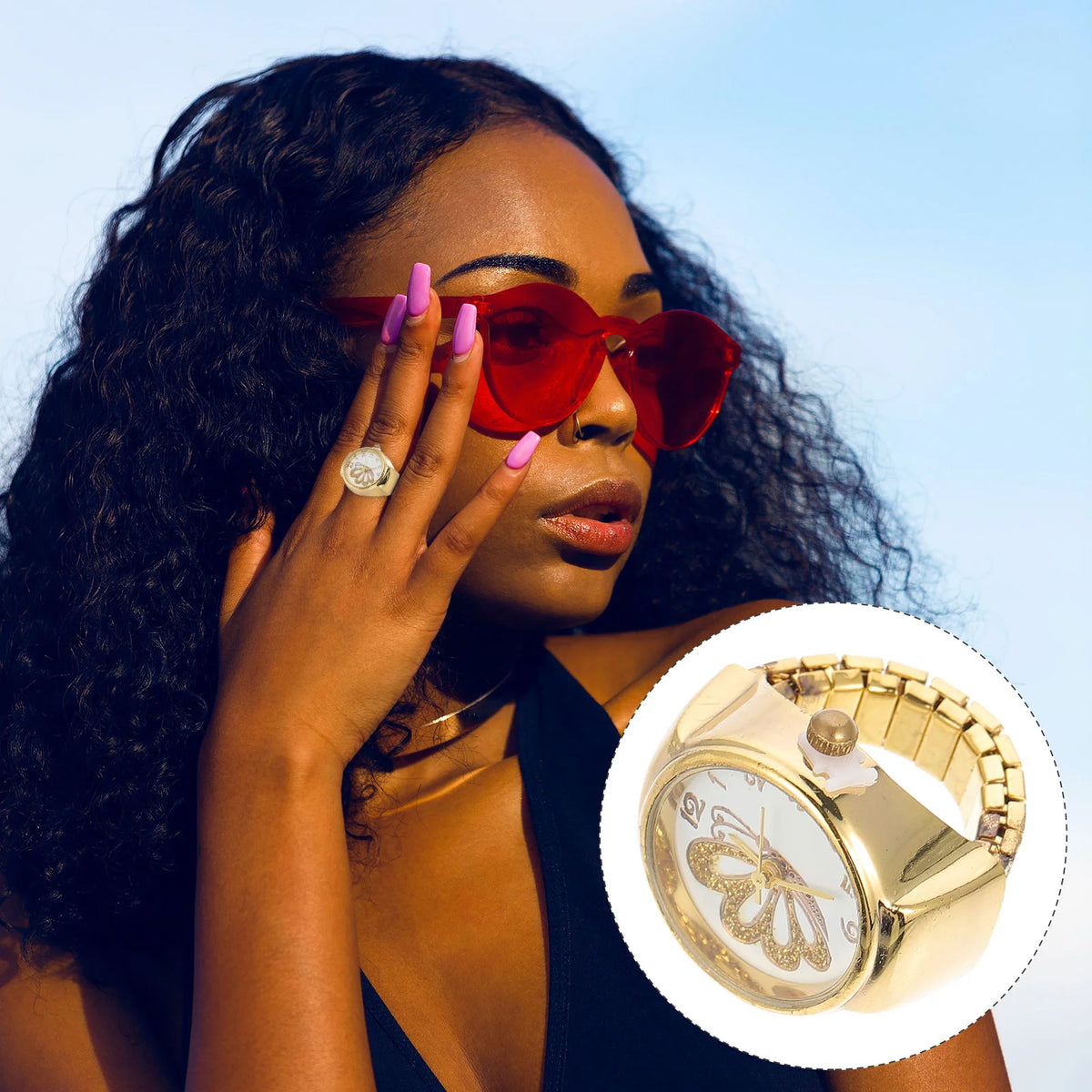 A woman with long curly hair and pink nails wears red sunglasses, elegant jewelry, and the Butterfly Ring Watch—a golden ring watch featuring a butterfly design. Inset highlights the gold watch face with delicate butterfly details.