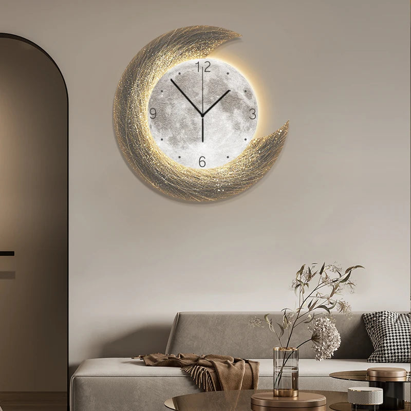 The Concentric Orbit Minimalist Wall Clock with a moon and crescent design hangs above a beige sofa in a neutral living room, accented by mood lighting and a glass vase on the round coffee table.