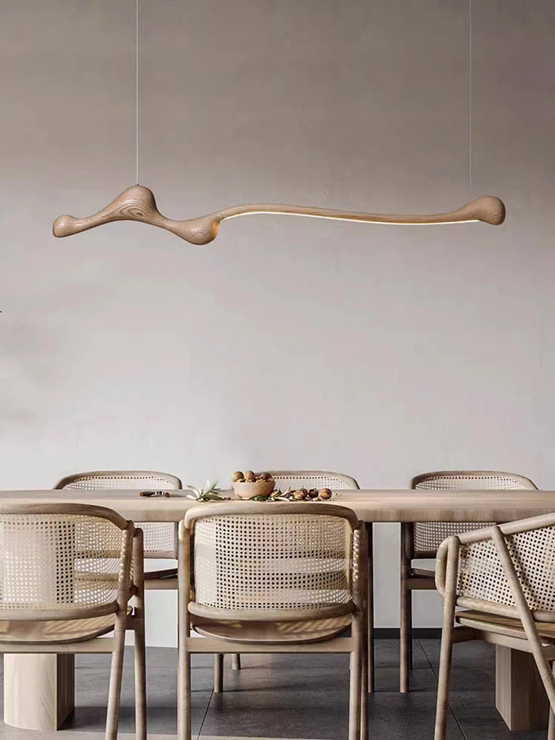 Minimalist dining room featuring a rectangular wooden table, six woven-back chairs, and the Tideform Biomorphic Pendant Light inspired by Nordic minimalism hanging above.