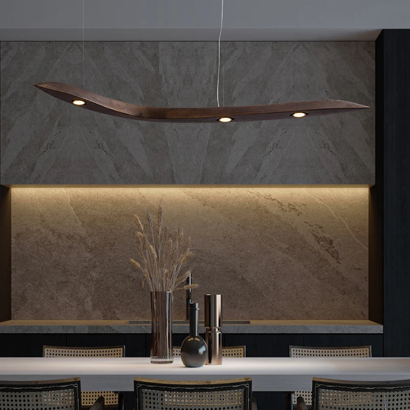 Modern kitchen interior with a stone backsplash, minimalist decor, and an organic touch from the Spiral Wood Pendant Light with three recessed lights above the dining table.