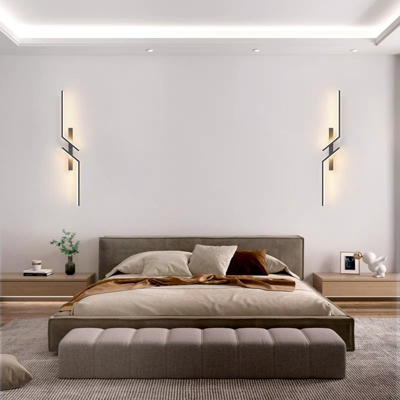 Modern bedroom with a low-profile bed, neutral bedding, nightstands, and simple decor on a wooden floor, enhanced by Minimalist Wall Sconce lighting for a stylish touch.
