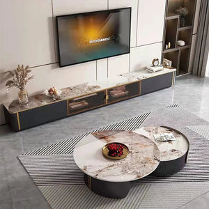 Modern living room with a wall-mounted TV, Luxe Round Coffee Table, long marble console, decorative items, and a striped rug on a gray floor.