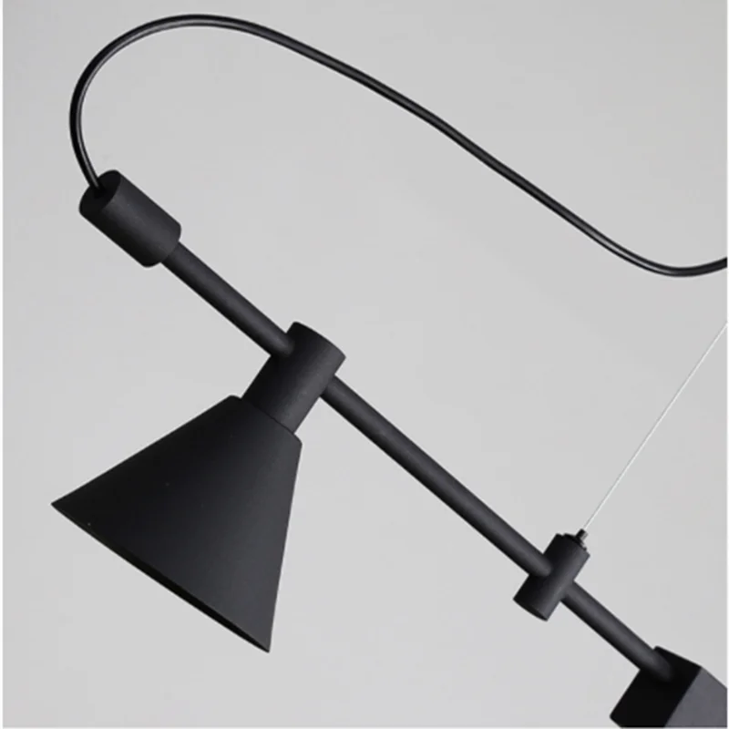 Close-up of Modern Track Lighting featuring an industrial-inspired black pendant lamp with a conical shade, suspended from the ceiling by a visible cord for a sleek touch.