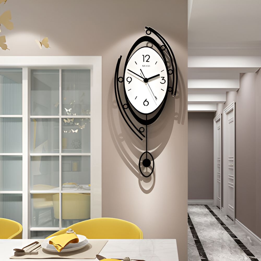The Zen Arc Oval Statement Clock, featuring a modern abstract black frame, hangs above a dining table with yellow chairs in a stylish contemporary room.