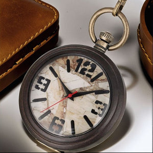 The Vintage Style Pocket Watch features a marble-patterned face, black numerals, and a red second hand, displayed beside a brown leather case—a classic example of marble face timepieces.