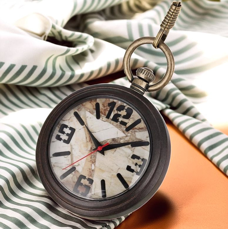 A Vintage Style Pocket Watch with a cracked face rests on striped fabric, its dark wood case and brown surface partially visible.