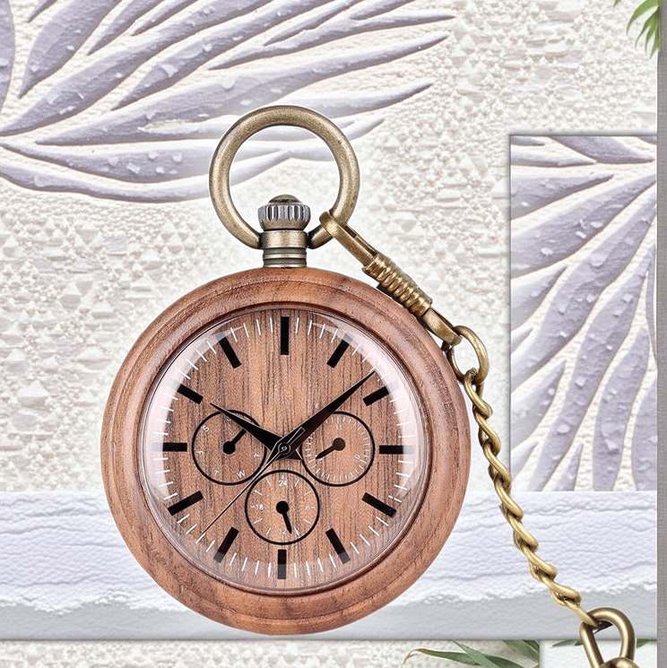 The Handmade Wood Pocket Watch, featuring black markings, three subdials, and a brass chain, is displayed against a textured pattern.
