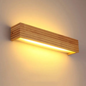 The Rectangle Wooden Wall Light showcases Scandinavian design, featuring natural wood and horizontal grooves in its LED sconce craftsmanship, emitting a warm glow.