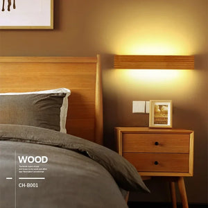 Bedroom with wooden headboard, bedside table, and a Rectangle Wooden Wall Light. A framed picture sits on the table. Bedding is gray and white, walls are beige. Text reads: "WOOD CH-B001.