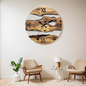 A Wood Circular Wall Clock with Roman numerals is mounted above two beige armchairs and a small table in an organic-style room. A live edge plant in a white pot on the left adds a touch of nature.