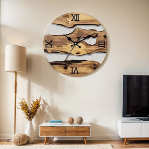 A Wood Circular Wall Clock with Roman numerals hangs above a modern console table, highlighting its organic style. To the right stands a TV, while a floor lamp and a vase filled with yellow flowers adorn the left.