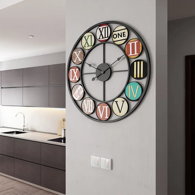 The Nordic Color-Ring Wall Clock features bold Roman numerals and vibrant colors, making a striking accent on a white wall in a modern kitchen.
