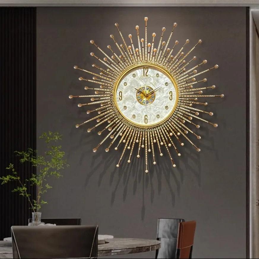 The Premium Sun Wall Clock with a decorative face hangs on a gray wall above a dining table, surrounded by chairs and a small green plant.