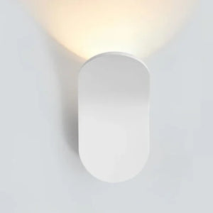 A modern, white Curved Wall Light is mounted on a white wall, enhancing living spaces with its soft, upward light.