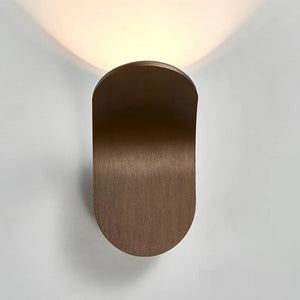 A minimalist Curved Wall Light featuring a Nordic wooden oval design, perfect for modern living spaces, illuminating the wall above it beautifully.