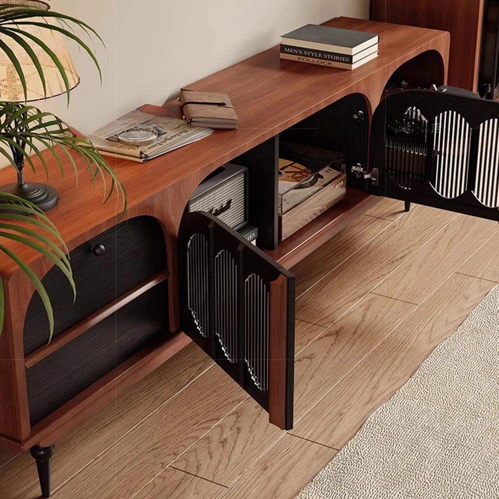 The Antique TV Cabinet Combo Set features open black cabinet doors showing shelves with books and decor. This wooden storage piece stands on wood flooring near a beige rug and a potted plant.