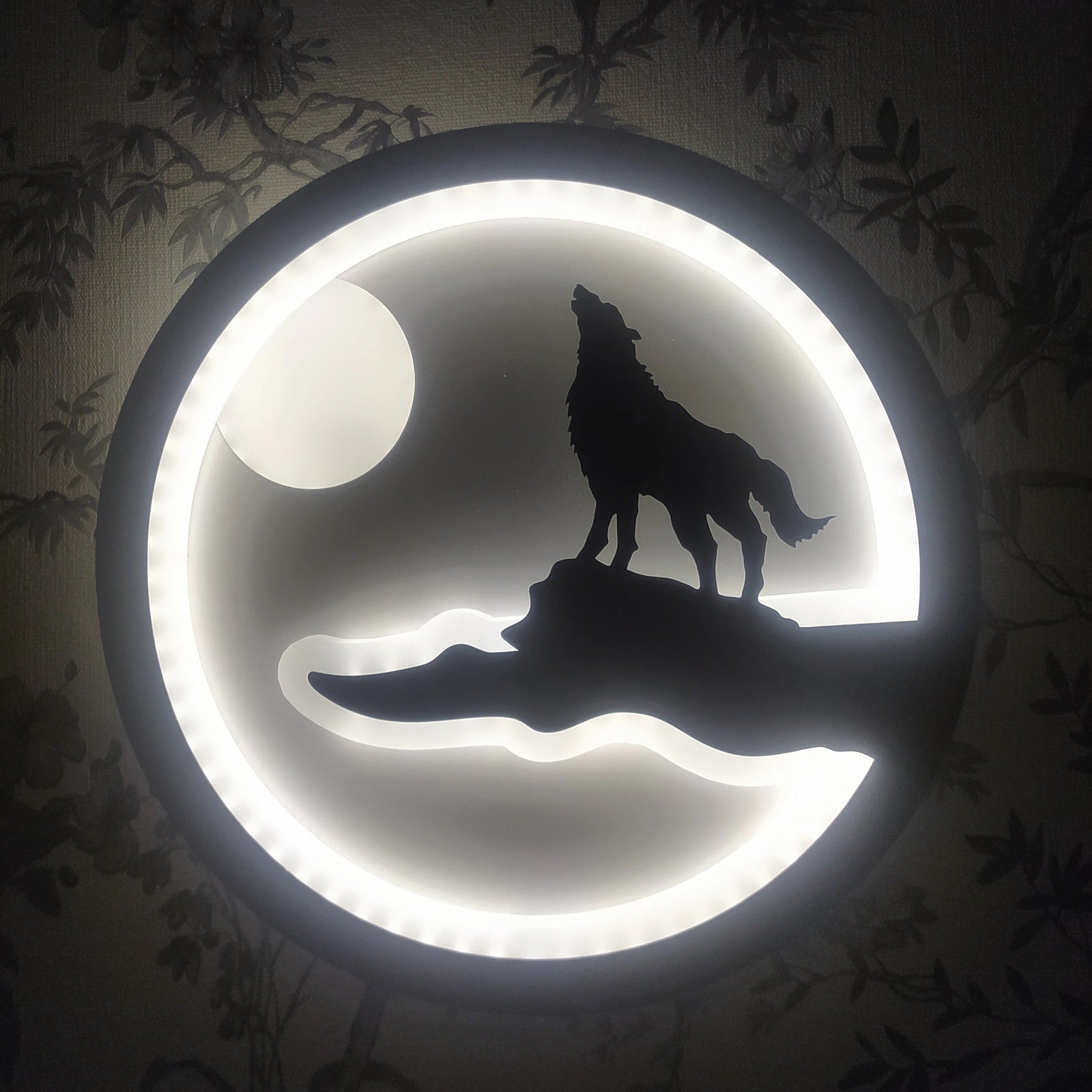 The Minimalist Wall Lamp features a design where a wolf howling on a cliff is softly illuminated by a circular LED light, creating the impression of the moon in the background—an ideal piece for infusing modern elegance into your home.