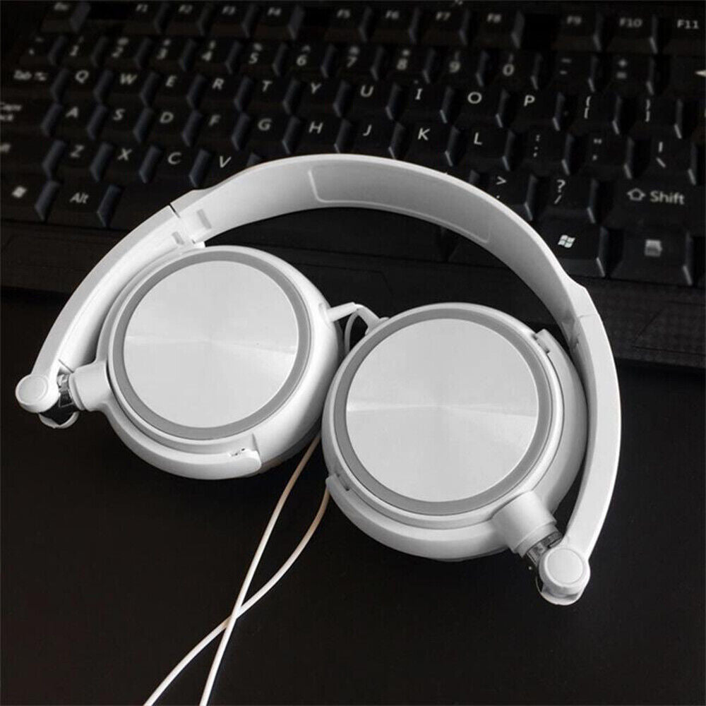 The Wired Bass Stereo Headphone, featuring an over-ear design and a headband, is shown in white resting on a black computer keyboard and desk.