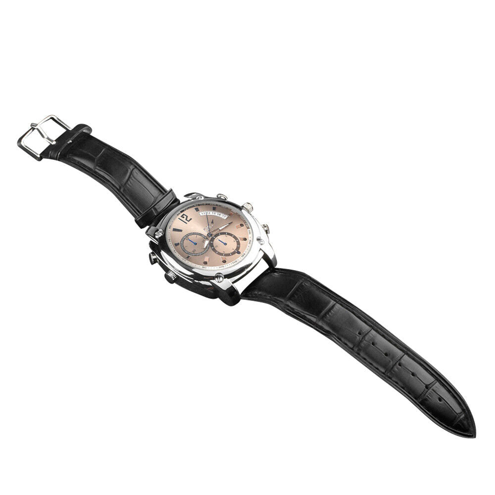 The Wristwatch SpyCam features a black leather strap, round light brown face with three subdials, silver case, and 1080P video recording for discreet surveillance, shown on a white background.