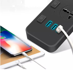 A smartphone and a tablet are charging via USB cables connected to the Power Strip SpyCam, a black power strip that features additional outlets, illuminated USB ports, and can covertly record in 1080P HD video quality.