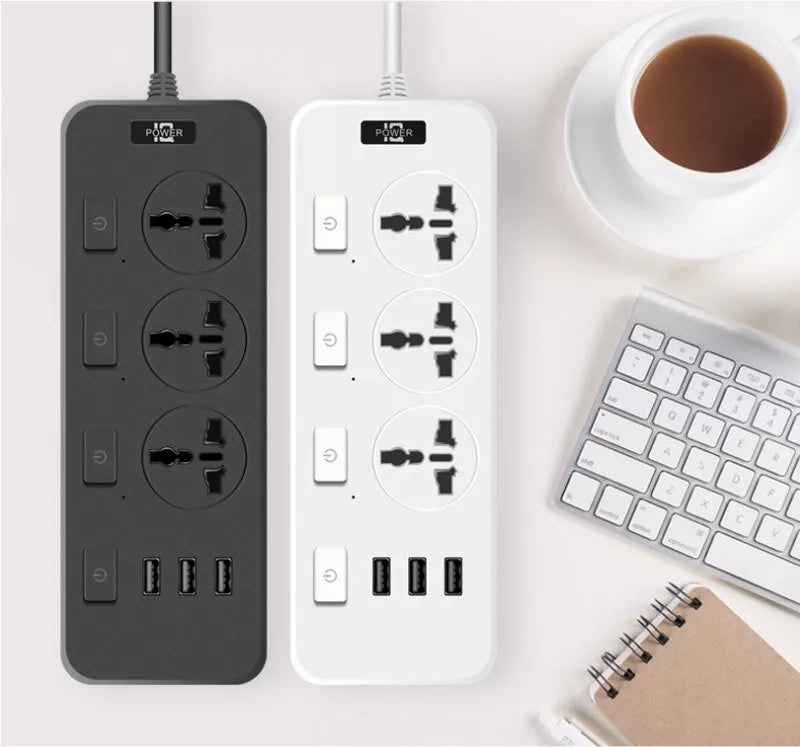 On a white surface, next to a keyboard, a notebook with a pen, and a cup of coffee, sit two power strips—one black and one white—each featuring multiple outlets and USB ports. One of these could be the discreet Power Strip SpyCam, offering 1080P HD video quality for covert surveillance.