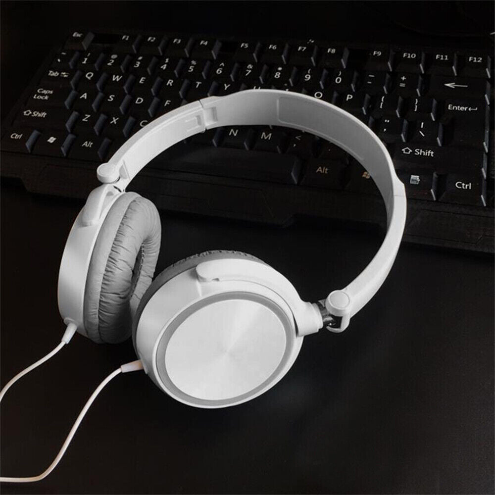The Wired Bass Stereo Headphone, featuring an over-ear design with gray ear cushions, is plugged in and resting on a black computer keyboard.