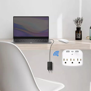 A desk with a laptop, mouse, and decor is showcased along with a mounted US Outlet SpyCam on the wall, featuring wireless capabilities, USB ports, and HD clarity. A charging cable connects the laptop to this outlet.