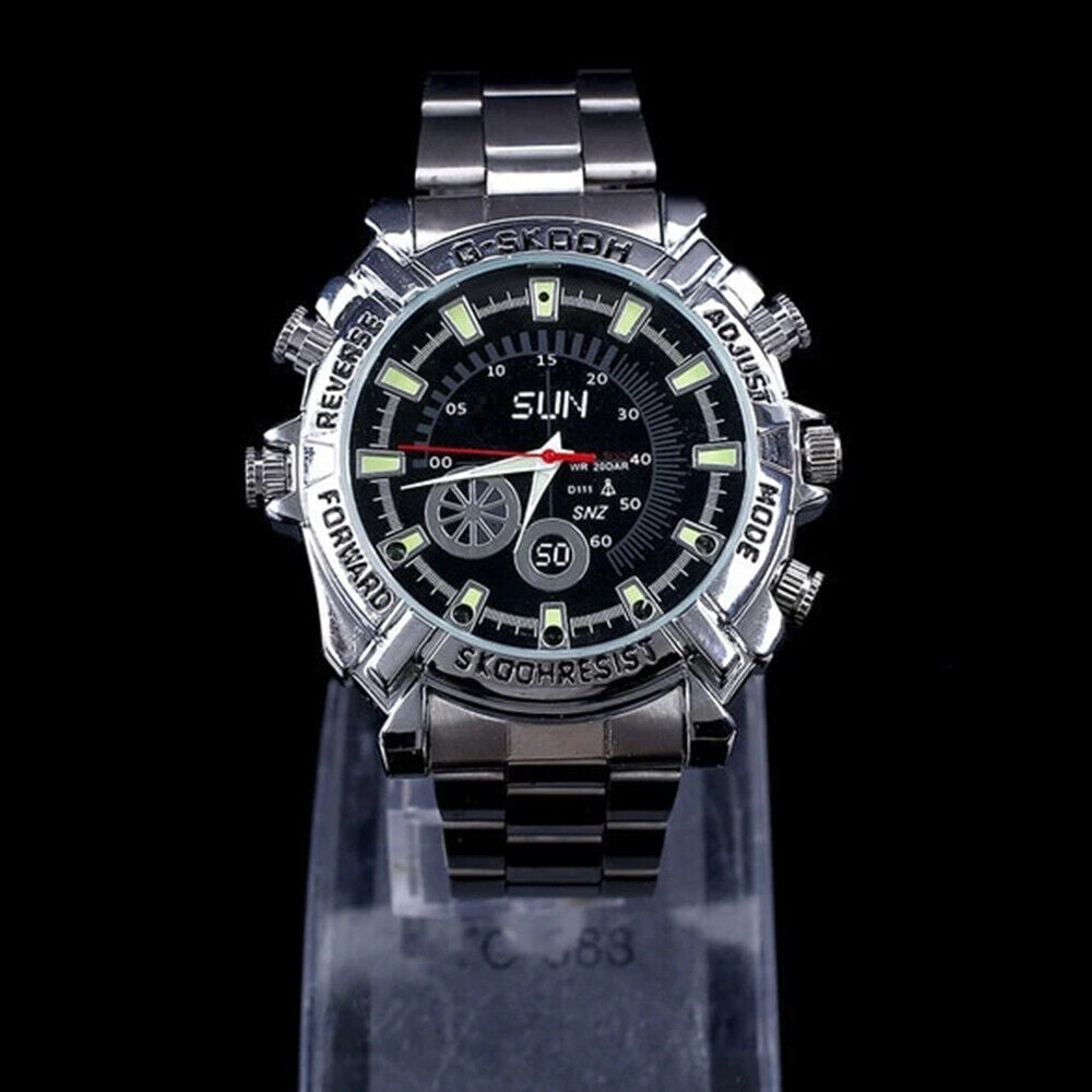 The Watch SpyCam is a silver metal wristwatch with a black dial, luminous markers, multiple buttons, and "SLIN" branding. It features a hidden 1080P camera for discreet video and audio recording and is shown on a stand against a black background.